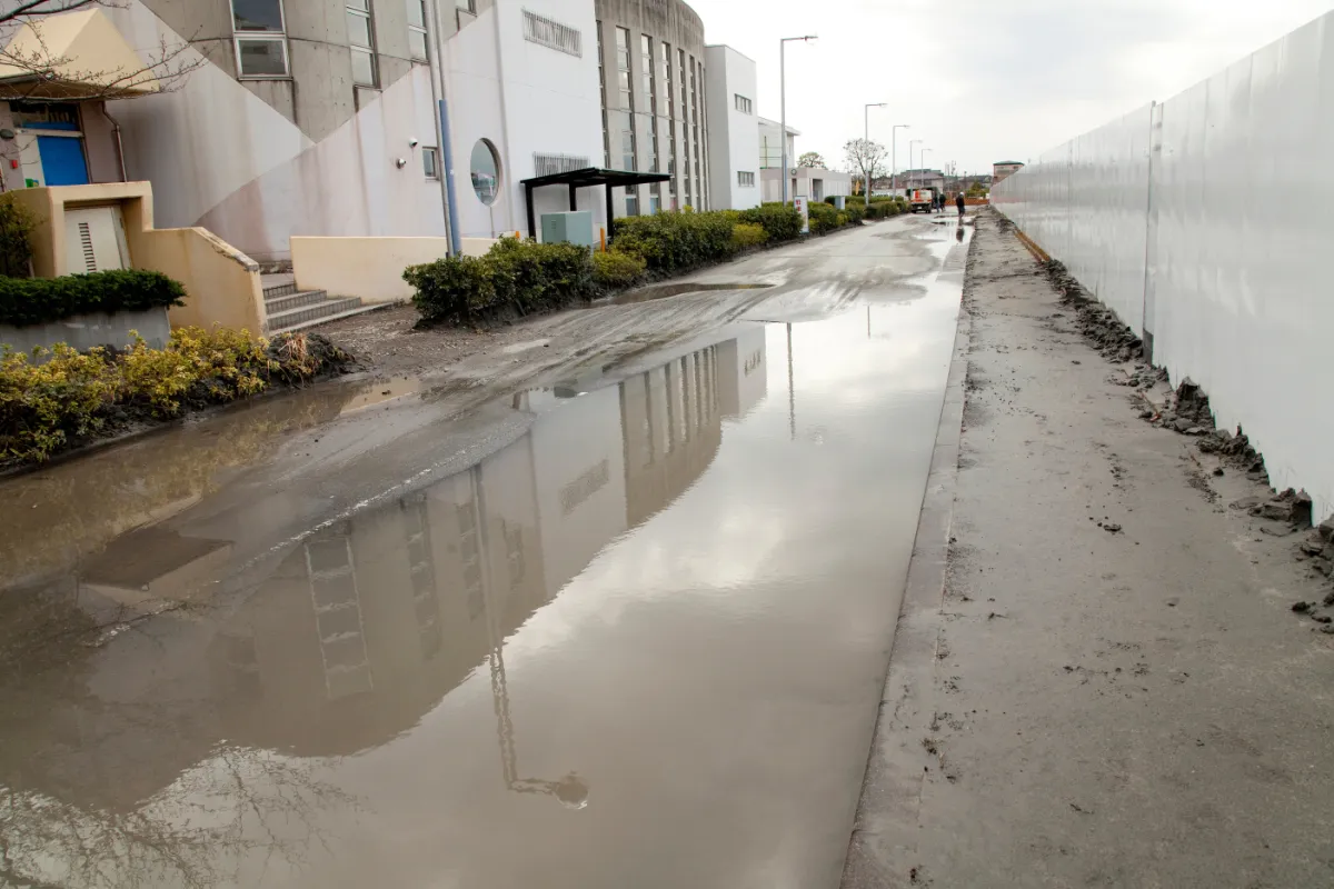 雨のあと大きな水たまりが残り、泥が堆積した道路